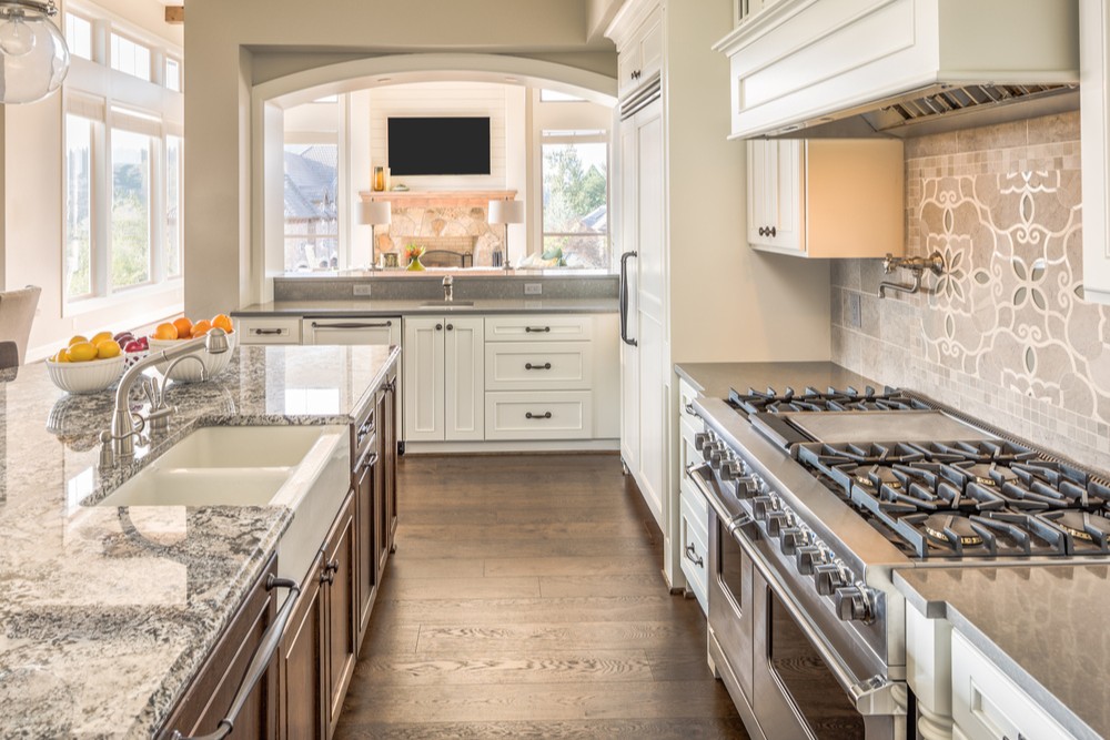 Kitchen Interior in New Luxury Home with Range, Oven, Sink, Cabinets, and Hardwood Floors
