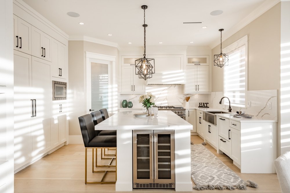 Warm white kitchen with expansive countertops island and high end appliances