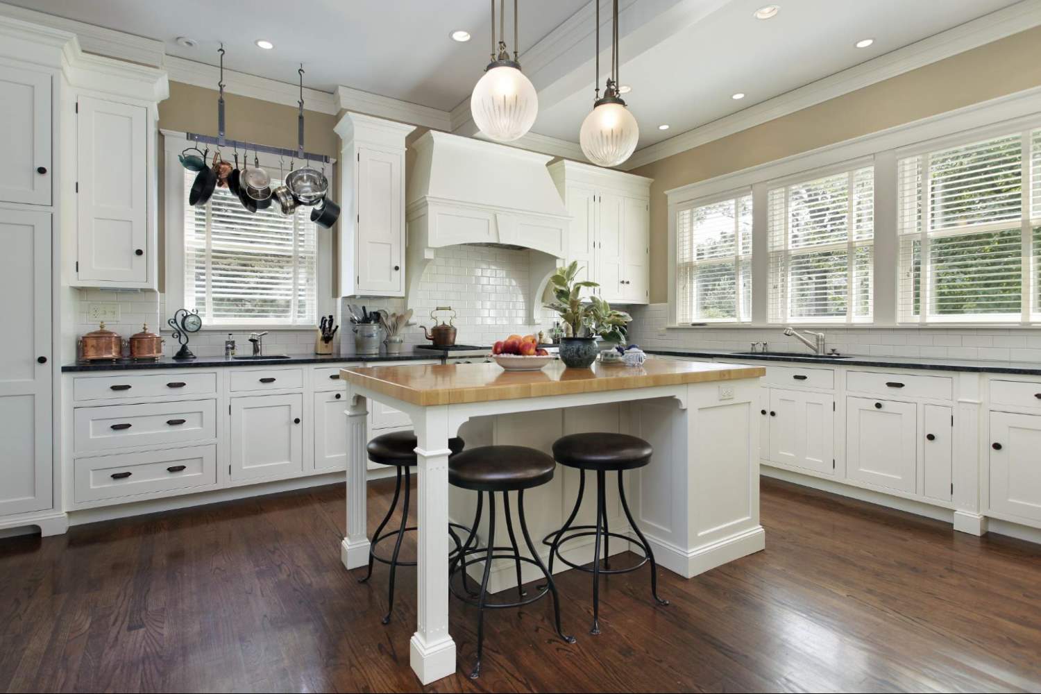 White Island with Wooden Countertop and Seating in a White Kitchen