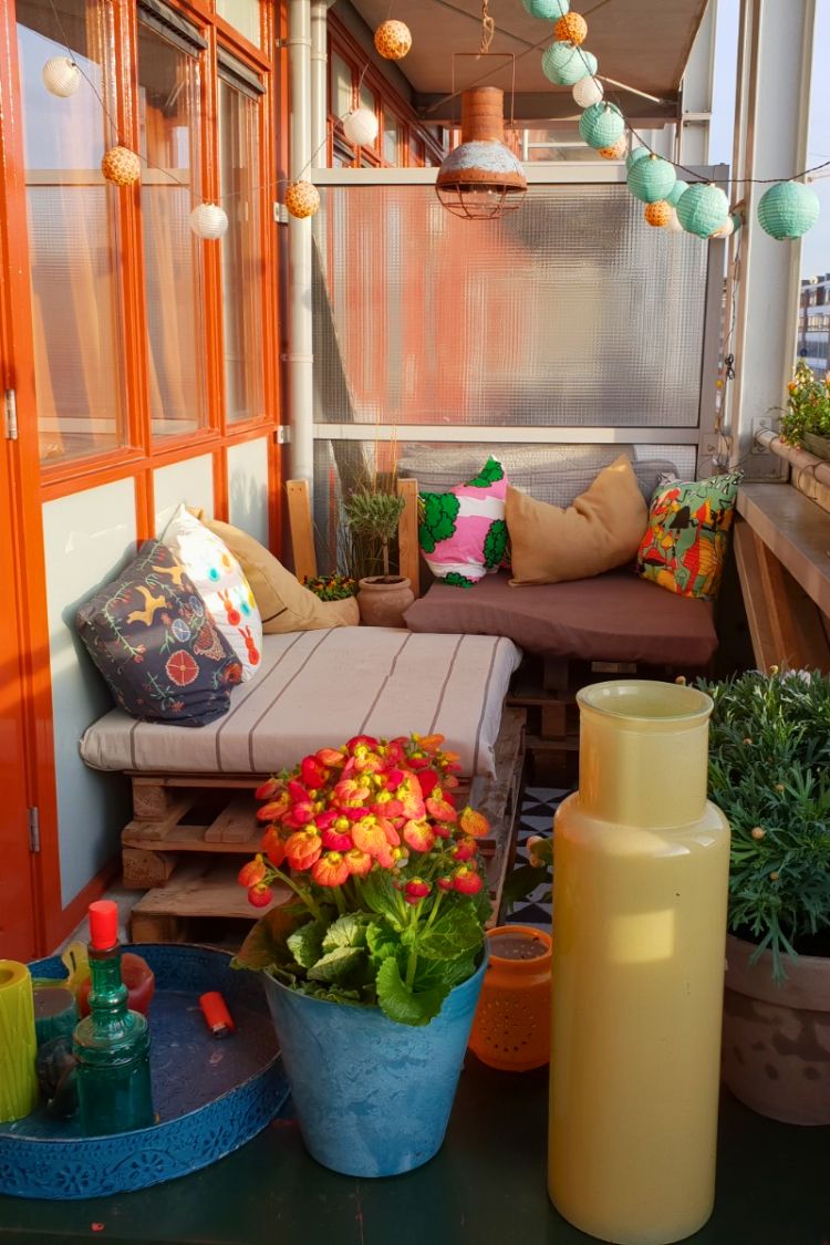 Indoor boho balcony with cozy seating and potted flowers
