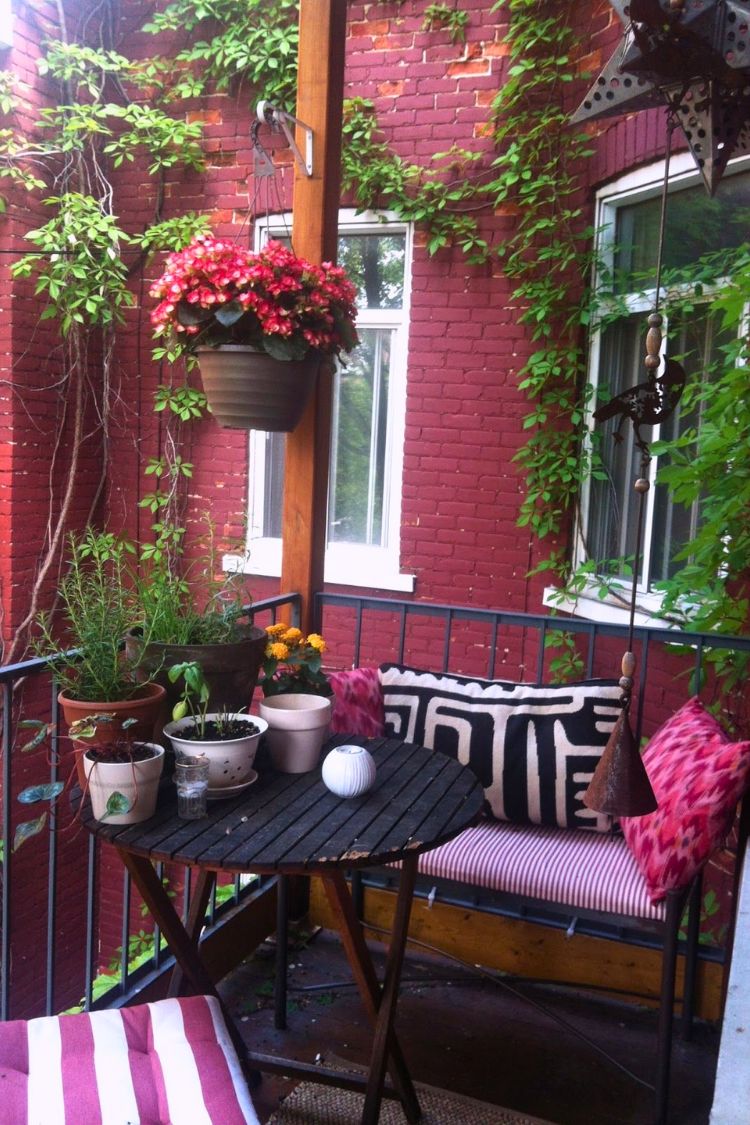 Romantic boho balcony with red accents and striped rug