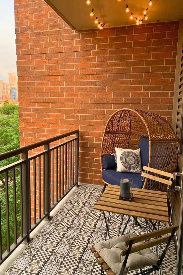 Simple boho balcony with egg chair and brick wall