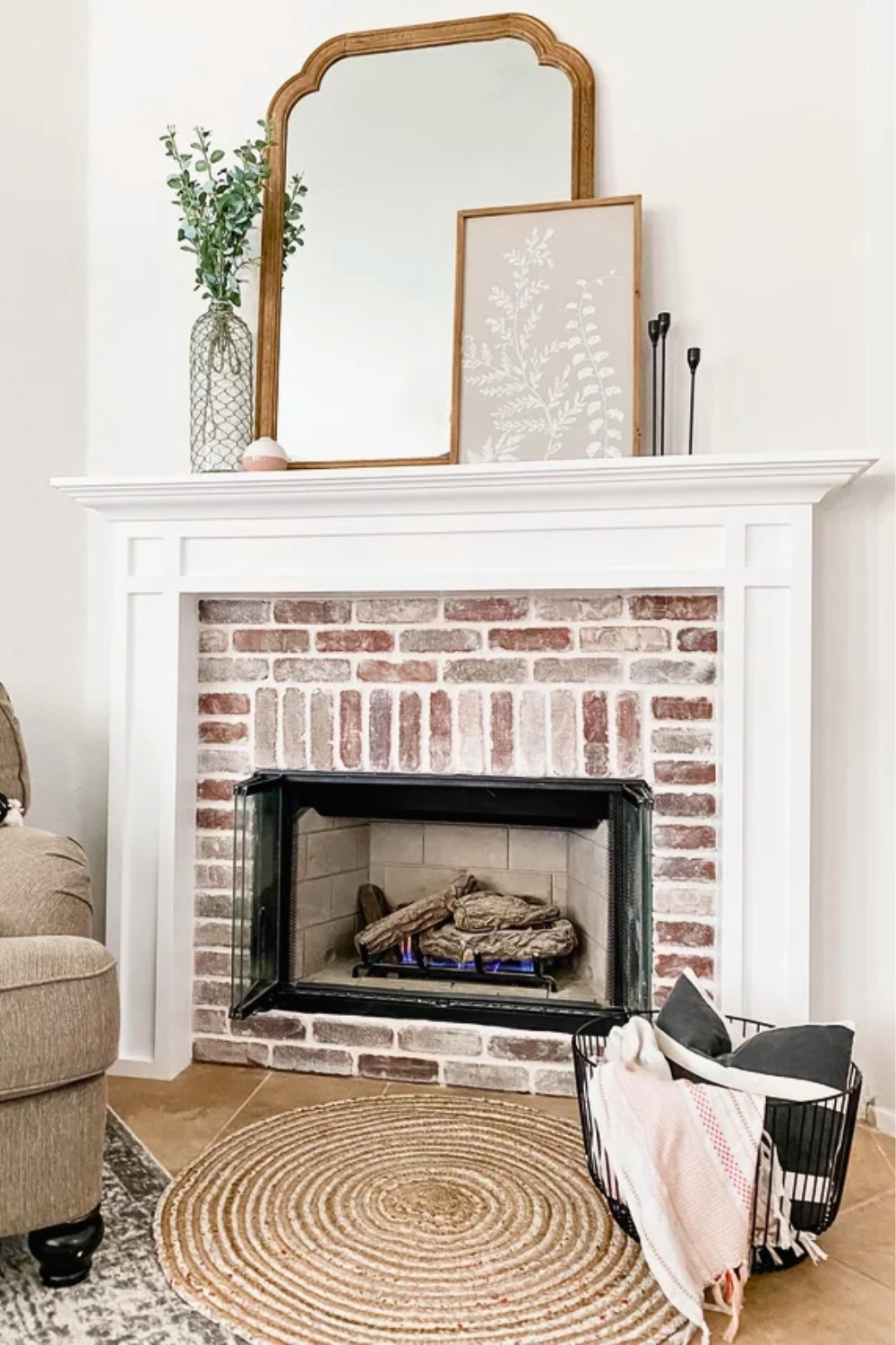 Minimalist Brick Fireplace Mantel with Large Arched Mirror, White Frame and Subtle Decor in a Cozy Neutral Living Space