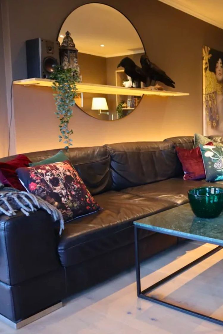 mirror with a speaker and a crow above the couch