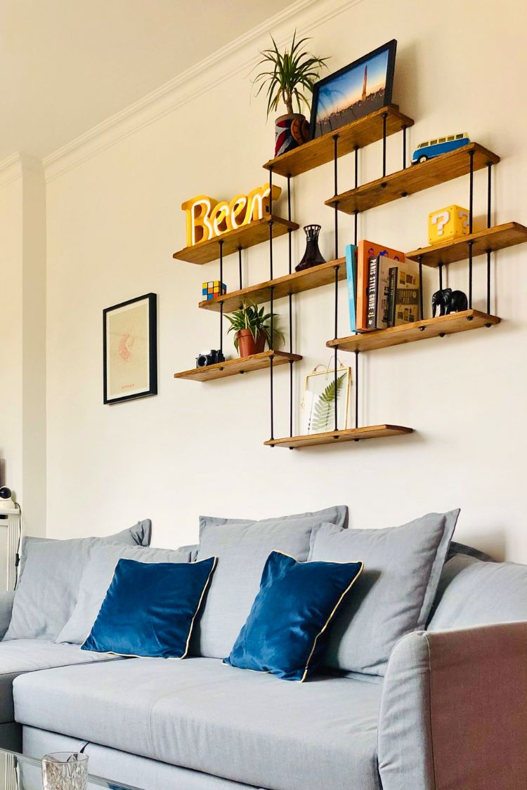 shelf with paintings above a couch