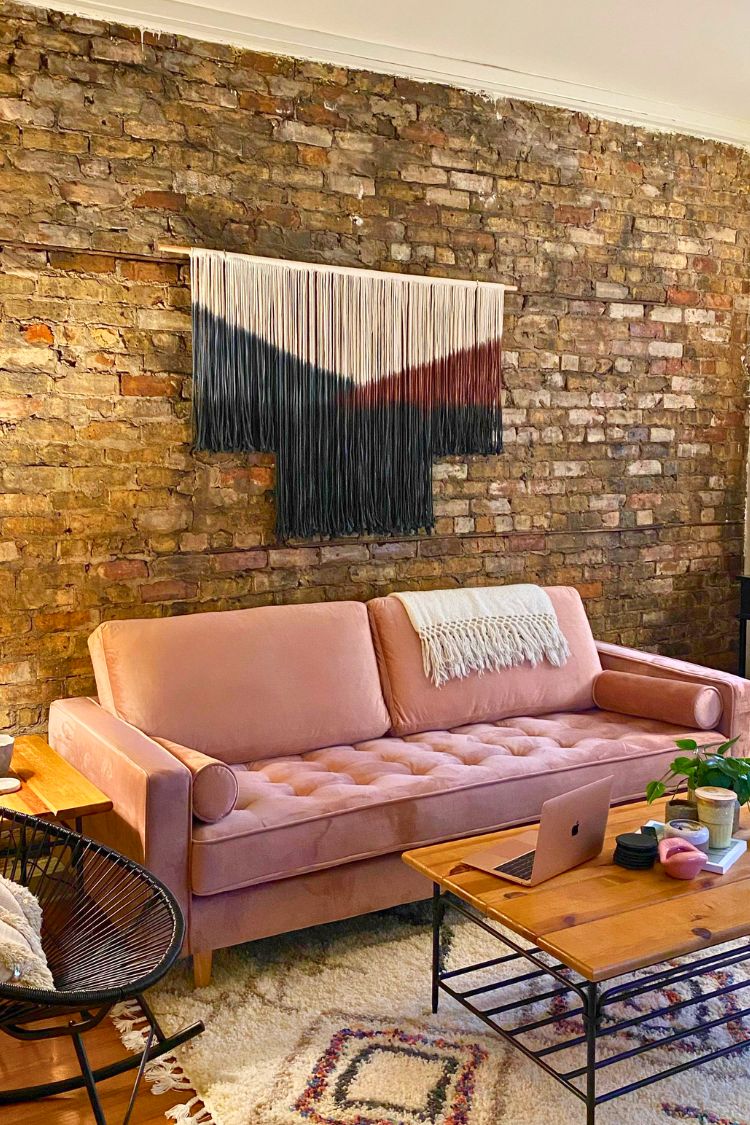 yarn wall hanging above a pink couch