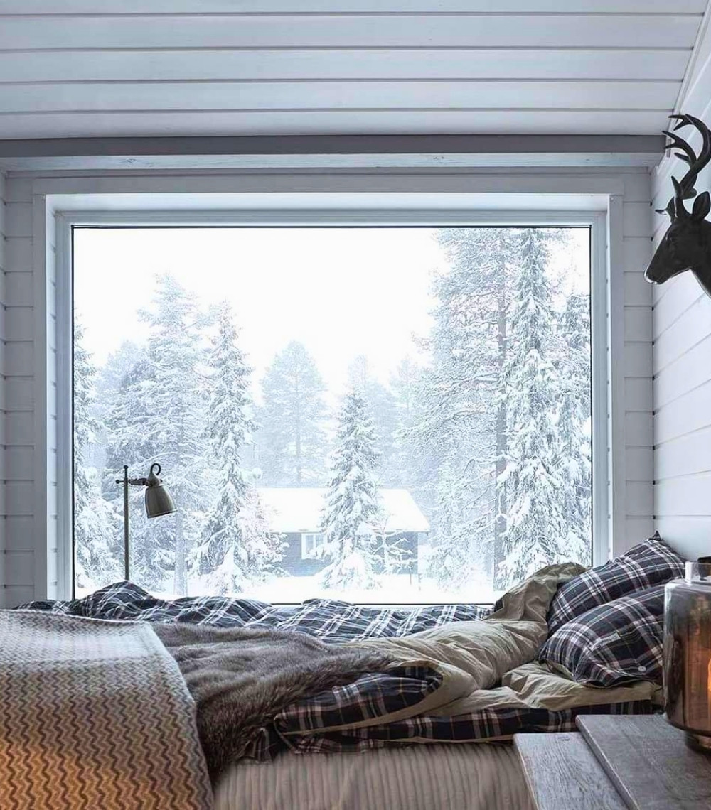 Winter Wonderland Bedroom With Forest View and Plaid Bedding in Finland